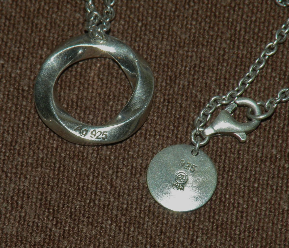 A sterling silver necklace: the round tag beside the clasp is stamped 925, and the pendant reads Ag 925.